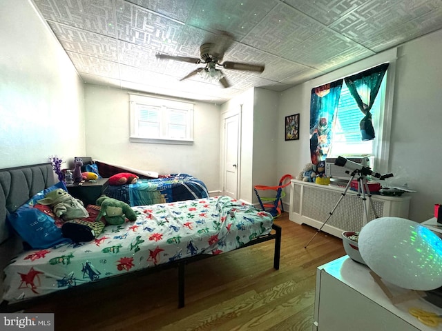 bedroom with ceiling fan and wood-type flooring