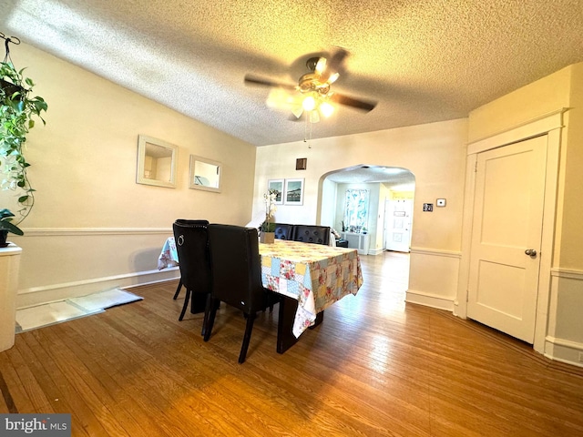 dining space with ceiling fan, a textured ceiling, and hardwood / wood-style floors