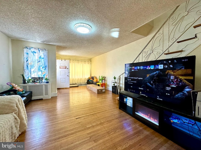 living room featuring a textured ceiling and hardwood / wood-style floors