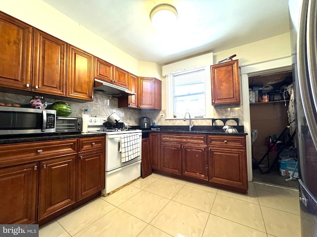 kitchen with sink, tasteful backsplash, white stove, and light tile patterned flooring