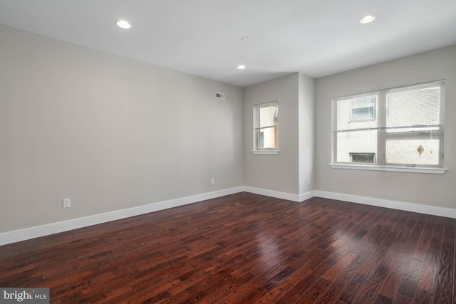 unfurnished room with dark hardwood / wood-style flooring