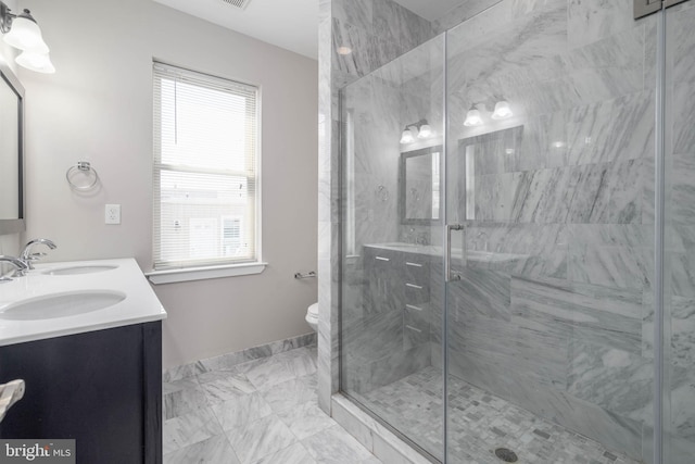 bathroom featuring vanity, a shower with shower door, and toilet