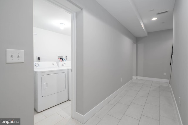 clothes washing area featuring washing machine and clothes dryer and light tile patterned floors