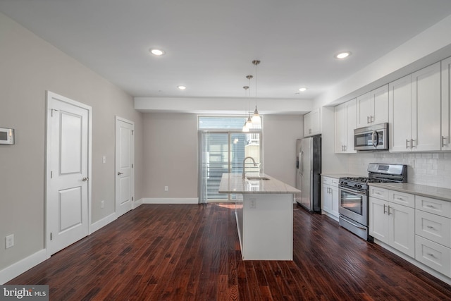 kitchen with white cabinetry, appliances with stainless steel finishes, sink, and hanging light fixtures