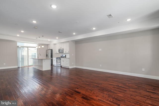 unfurnished living room featuring dark hardwood / wood-style flooring and sink