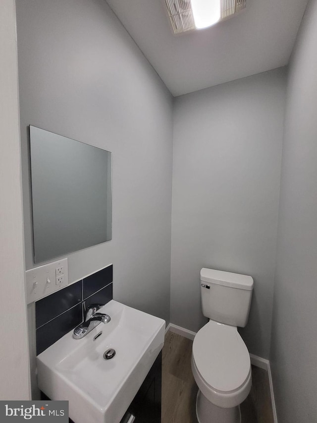 bathroom with vanity, wood-type flooring, and toilet