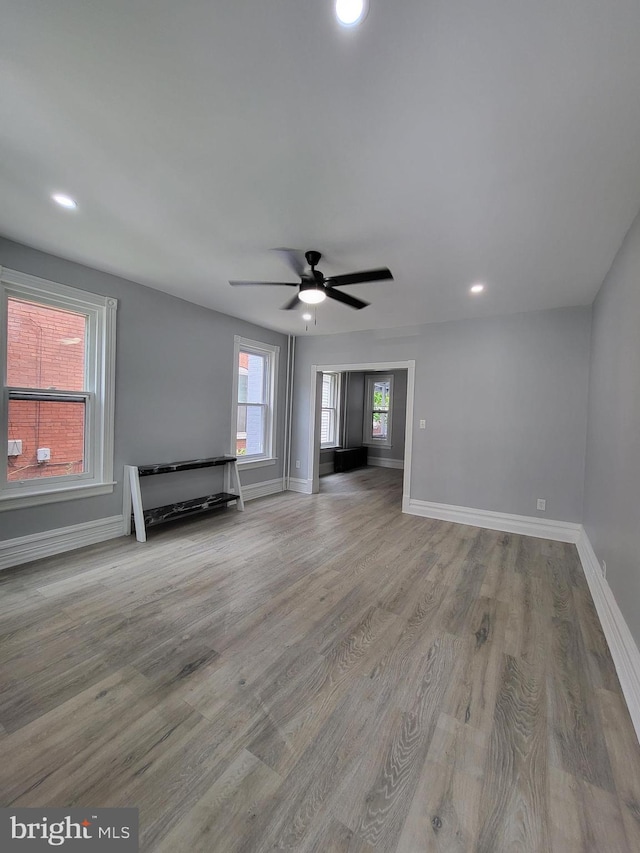 unfurnished living room featuring wood-type flooring and ceiling fan