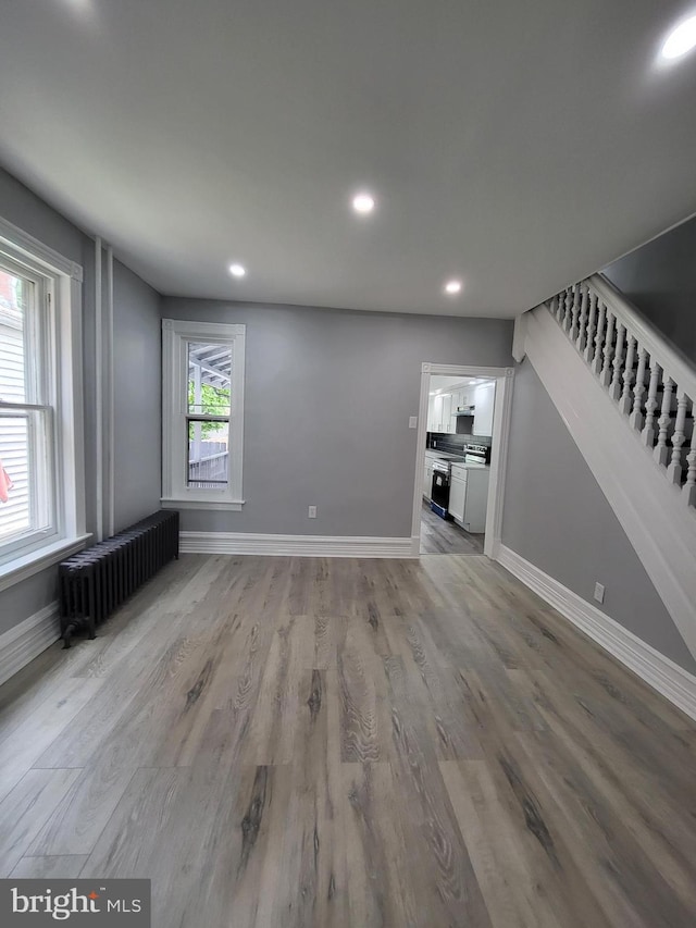 unfurnished living room featuring radiator and light hardwood / wood-style floors