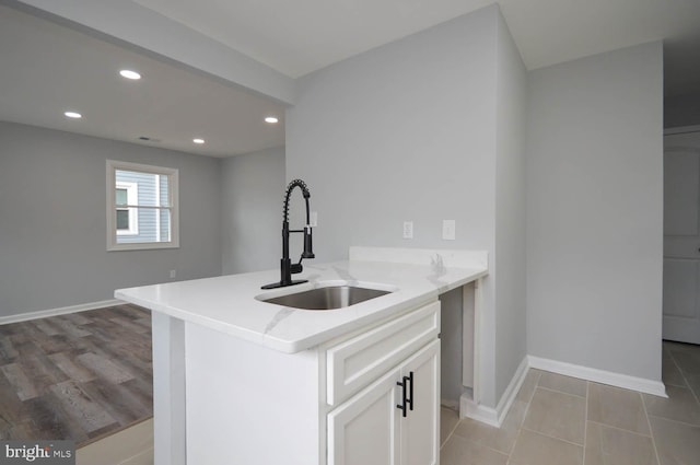 kitchen featuring white cabinets, light hardwood / wood-style floors, and sink