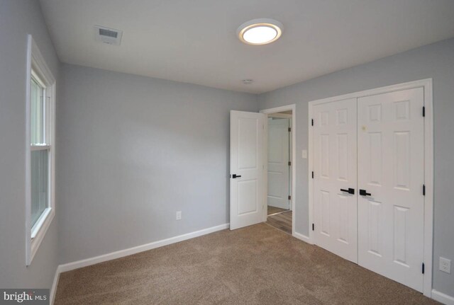 unfurnished bedroom with carpet and a closet