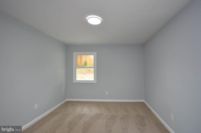 unfurnished room featuring light carpet