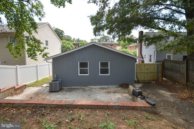 back of property with central AC unit and a patio