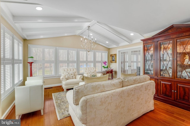 living room with a chandelier, light hardwood / wood-style floors, and lofted ceiling with beams