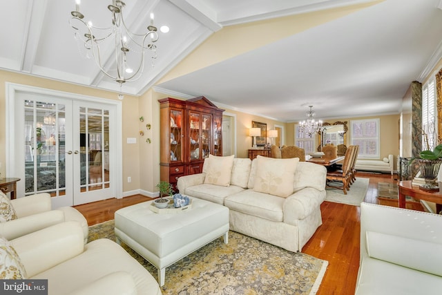 living room featuring wood-type flooring, french doors, an inviting chandelier, ornamental molding, and lofted ceiling with beams