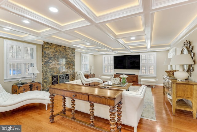 living room featuring a fireplace, light hardwood / wood-style floors, ornamental molding, beam ceiling, and coffered ceiling