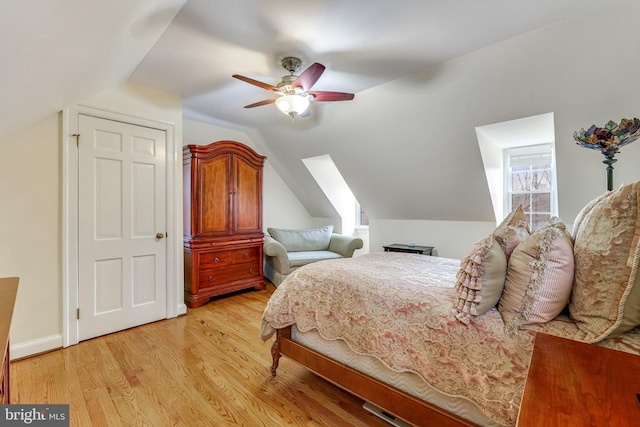 bedroom with ceiling fan, vaulted ceiling, and light wood-type flooring