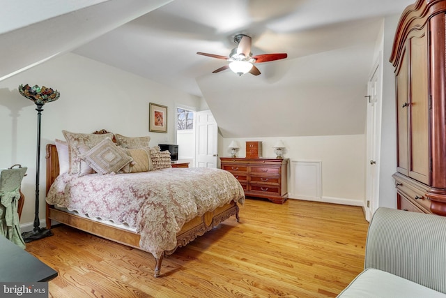 bedroom featuring ceiling fan, light hardwood / wood-style floors, and vaulted ceiling