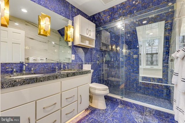 bathroom with tile walls, toilet, walk in shower, and vanity