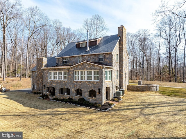 view of front facade with a front yard and central AC unit