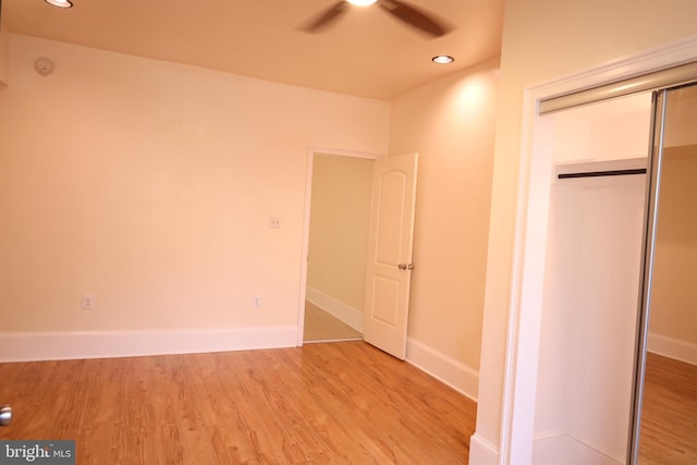 unfurnished bedroom with ceiling fan, a closet, and light hardwood / wood-style floors