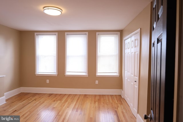 unfurnished room with light wood-type flooring and a healthy amount of sunlight