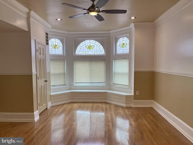 empty room featuring wood-type flooring, ornamental molding, and ceiling fan