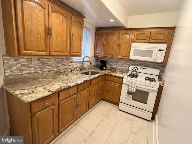 kitchen with light tile patterned floors, sink, white appliances, tasteful backsplash, and light stone countertops