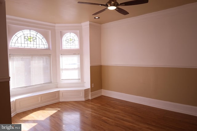 empty room with ornamental molding, ceiling fan, and wood-type flooring