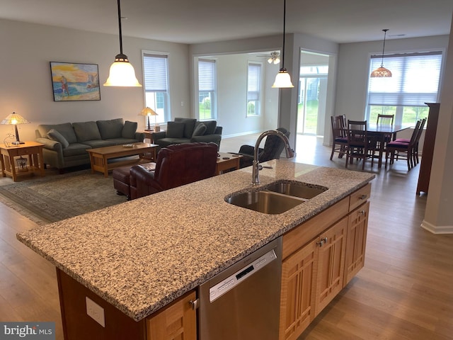 kitchen with sink, an island with sink, dishwasher, and light hardwood / wood-style floors