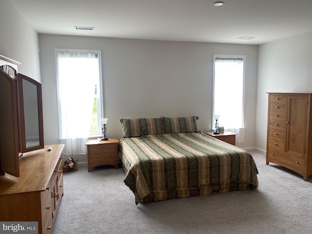 carpeted bedroom featuring multiple windows