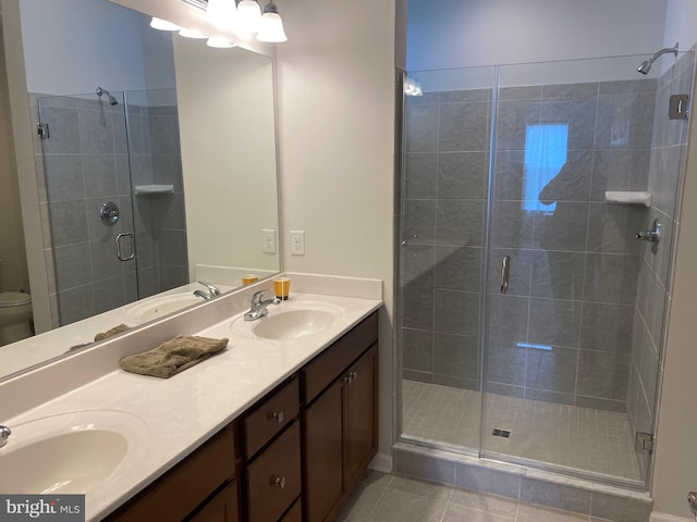 bathroom with vanity, an enclosed shower, toilet, and tile patterned flooring