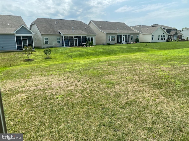 back of house with a yard and a sunroom