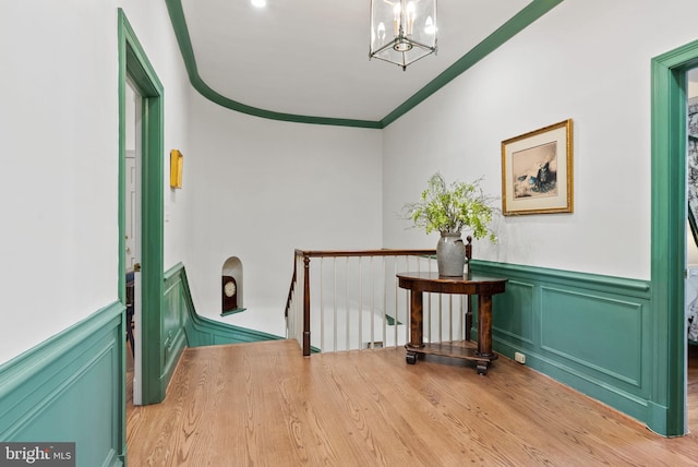 interior space featuring crown molding, an inviting chandelier, and light hardwood / wood-style floors