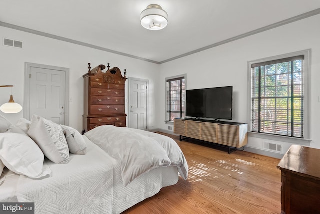 bedroom with crown molding and light hardwood / wood-style flooring