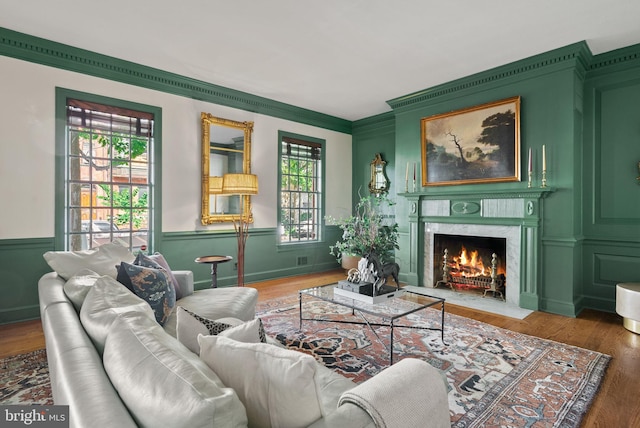 living area with a premium fireplace, dark hardwood / wood-style floors, and crown molding