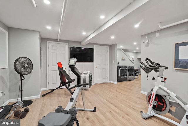 exercise area featuring washer and clothes dryer and light wood-type flooring