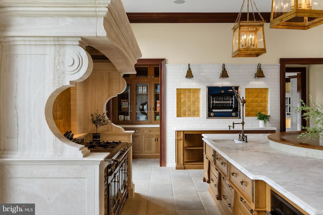 kitchen featuring ornamental molding, sink, and decorative light fixtures