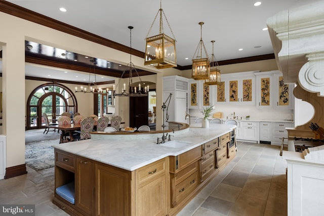 kitchen featuring a large island, backsplash, light stone countertops, and white cabinets