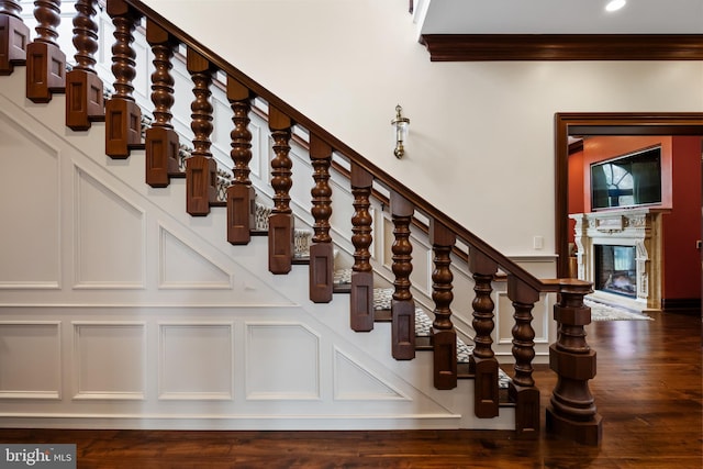 stairs with hardwood / wood-style floors and ornamental molding