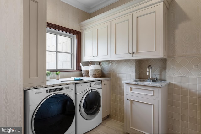 laundry room featuring independent washer and dryer, cabinets, crown molding, and sink