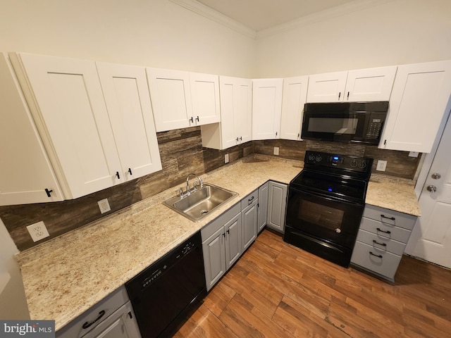 kitchen with tasteful backsplash, black appliances, gray cabinetry, crown molding, and dark hardwood / wood-style flooring