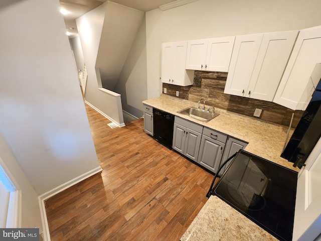 kitchen with range, sink, black dishwasher, light hardwood / wood-style flooring, and backsplash