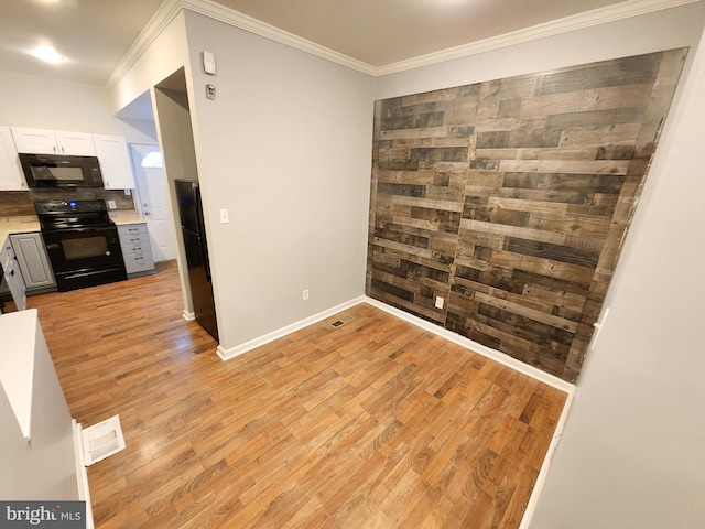 spare room with ornamental molding and light hardwood / wood-style floors