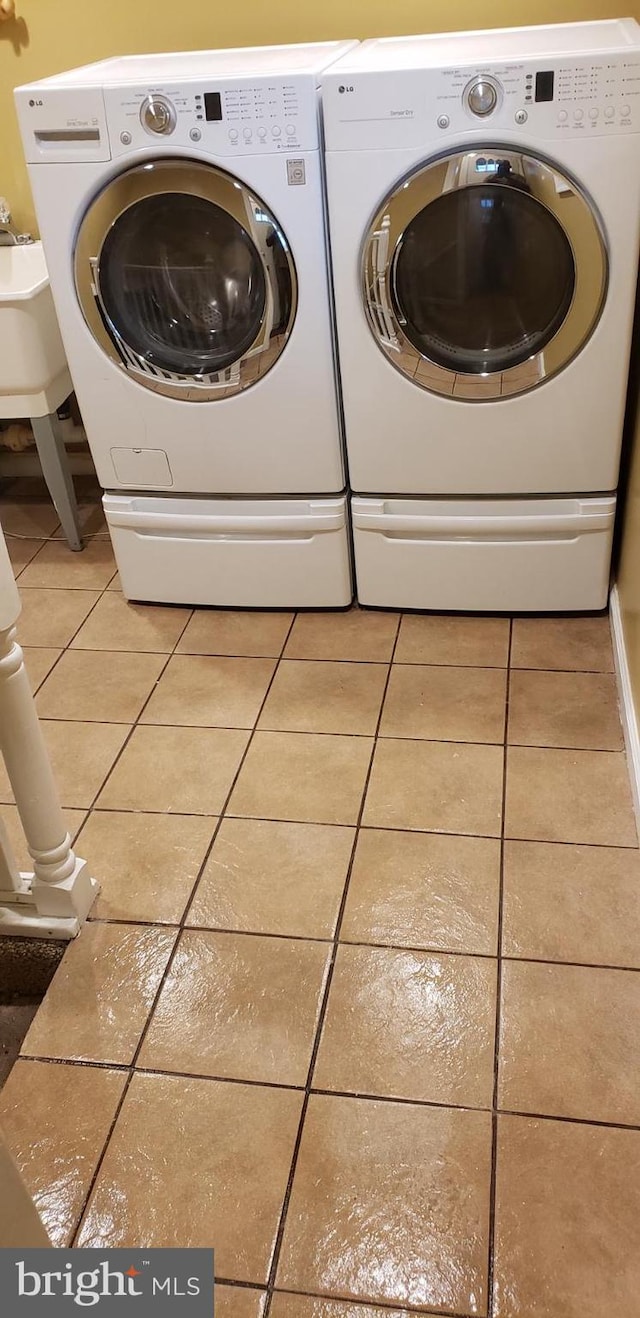 clothes washing area featuring separate washer and dryer and light tile patterned flooring