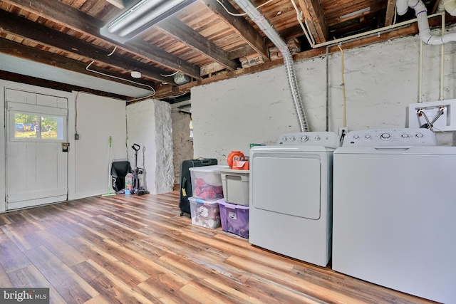 washroom with washing machine and clothes dryer and wood-type flooring