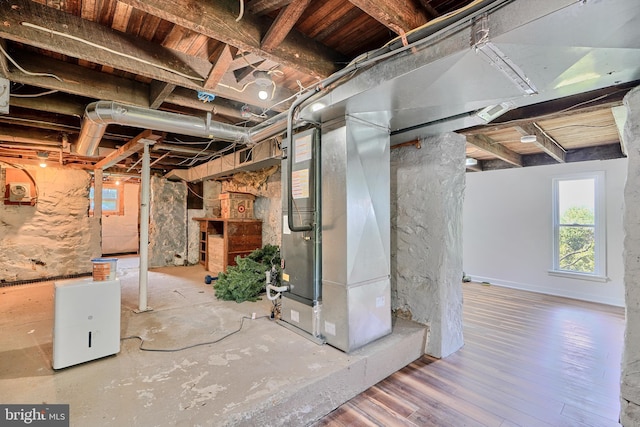 basement featuring heating unit and hardwood / wood-style floors