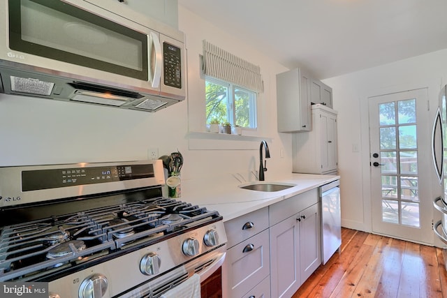 kitchen with sink, light hardwood / wood-style flooring, and appliances with stainless steel finishes