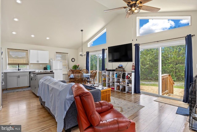 living room with sink, light hardwood / wood-style flooring, high vaulted ceiling, and ceiling fan