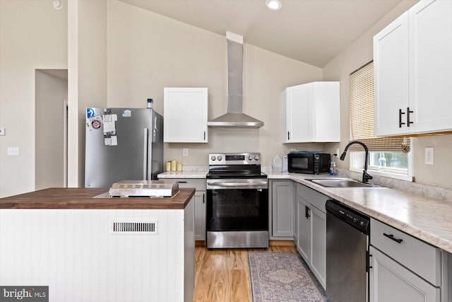 kitchen with stainless steel appliances, white cabinetry, sink, and wall chimney exhaust hood