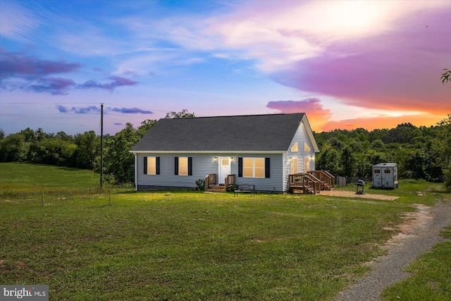 view of front of home with a lawn and a storage unit